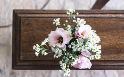 Coffin with white and pink flowers on top
