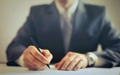 Cut off image of a man in a suit signing a contract