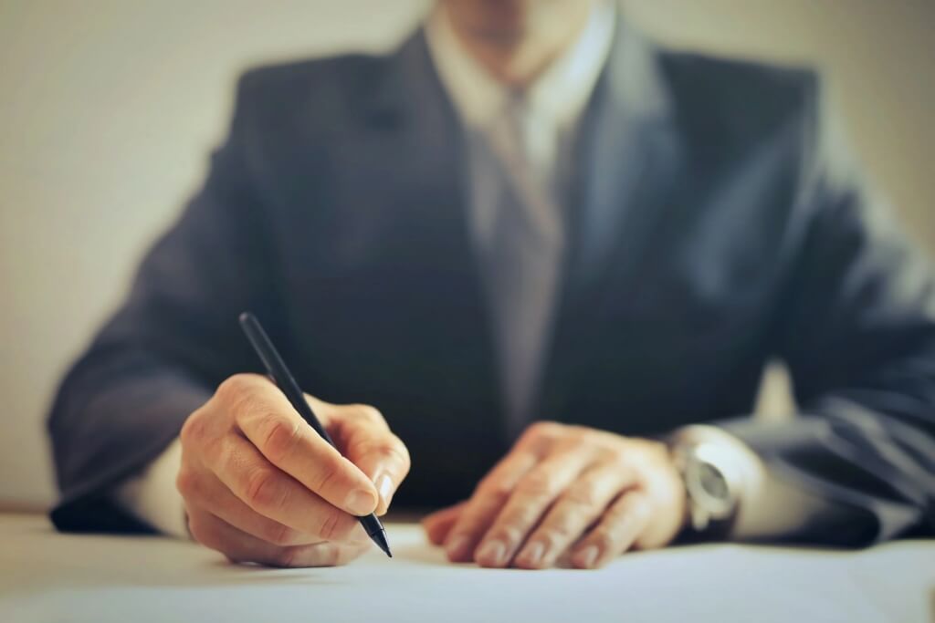 Pexels Licence - Andrea Piacquadio Cut off image of a man in a suit signing a contract