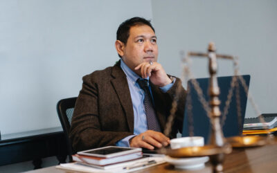 Male judge sitting at desk with a set of scales