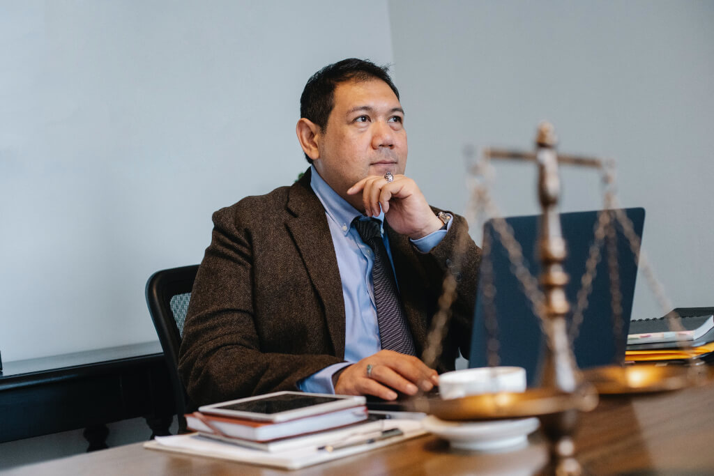 Male judge sitting at desk with a set of scales