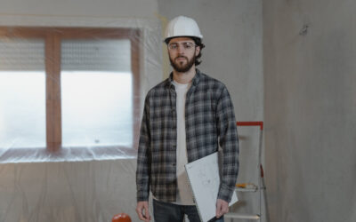 Man in a hard hat holding construction plans