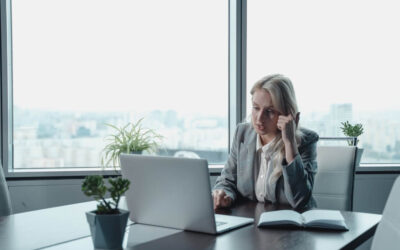 Female company director in a suit on her laptop in a high office