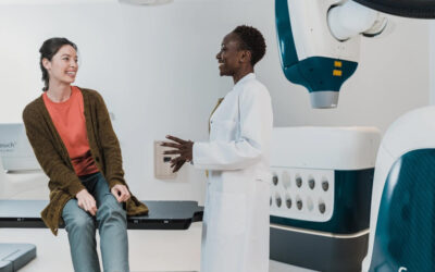 Doctor talking to patient sat on examination bed