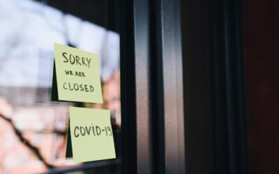 Post-it notes on a business saying "Sorry We Are Closed. COVID-19"