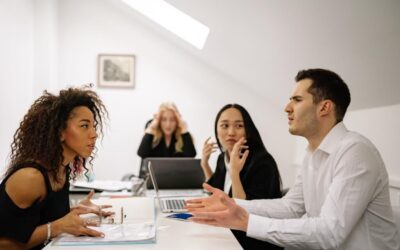 Four people having a dispute across a desk