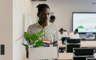 Fired man carry his stuff away from his desk