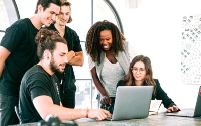 Team of people crowded around a laptop