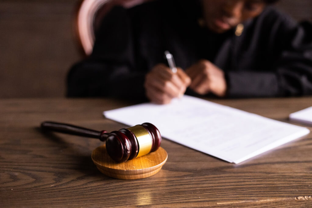 Judge signing papers with gavel in front