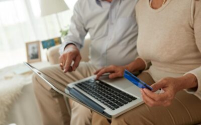 Two people looking at a laptop with a credit card