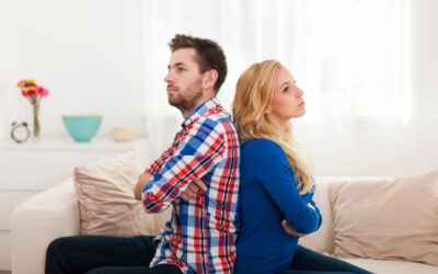 Couple sitting back to back looking fed up