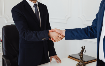 Two people in business suits shaking hands in a law firm office
