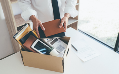 A business man packing up his desk after being dismissed from his office workspace