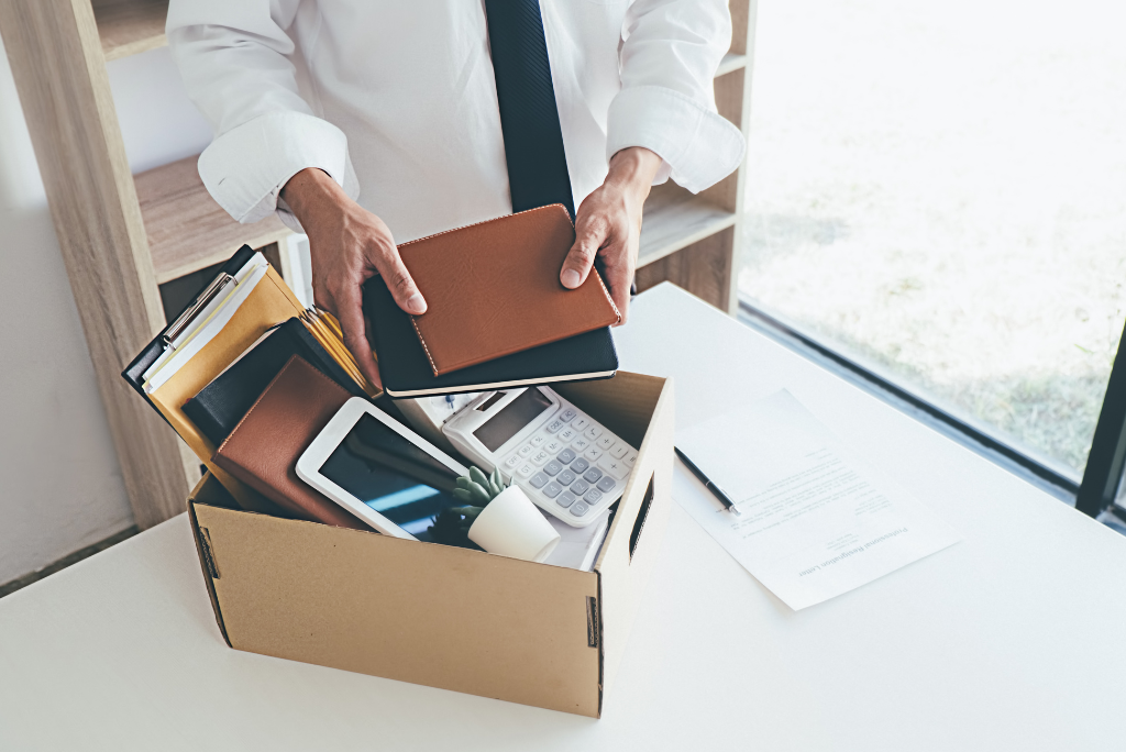 A business man packing up his desk after being dismissed from his office workspace
