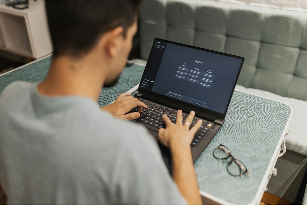 A man working on a laptop with AI Tool ChatGPT on his screen for work